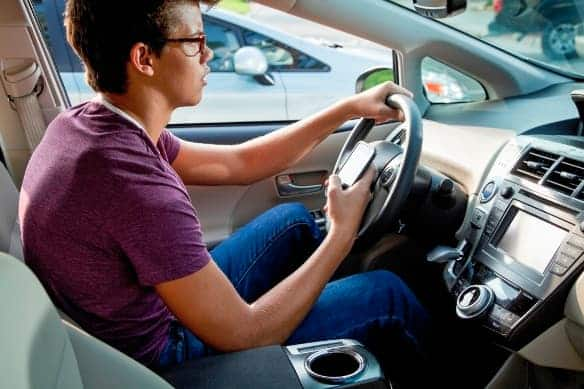 Teen texting and driving in car alone