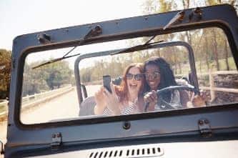 Two girls taking selfie in Jeep