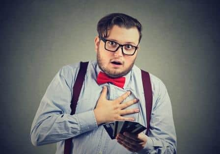 Young man looking suprised holding credit cards